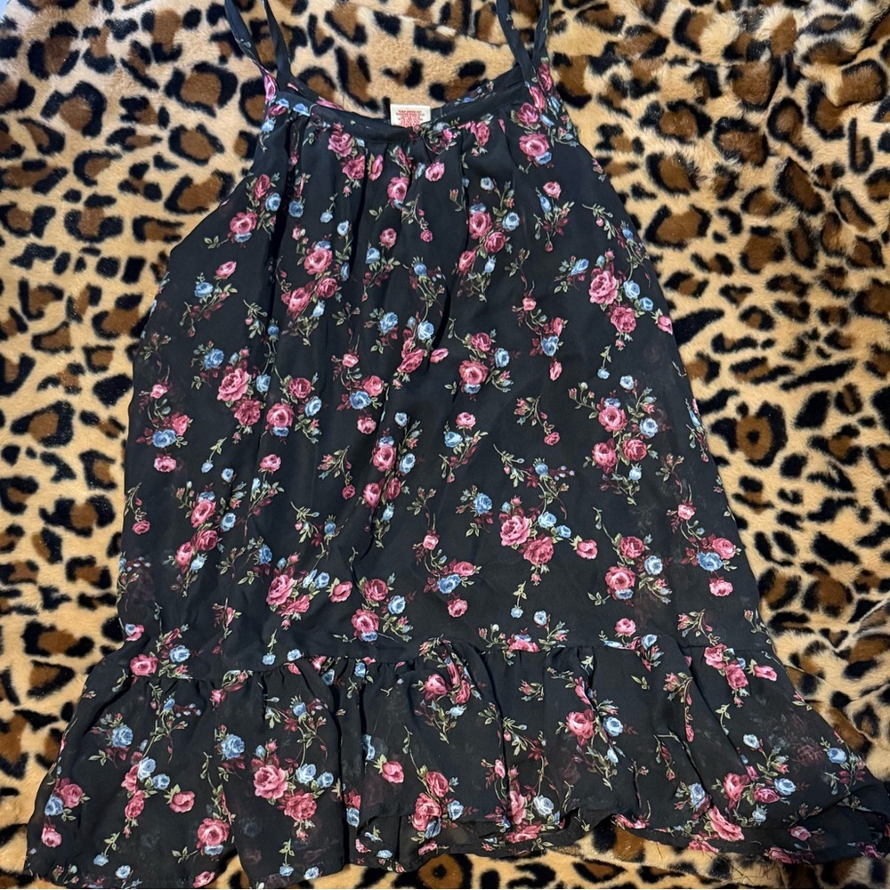 Black/pink floral top with spaghetti straps and skirt-like ruffles at bottom.